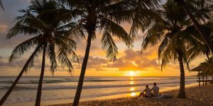 Retired couple enjoying a beach sunset together.